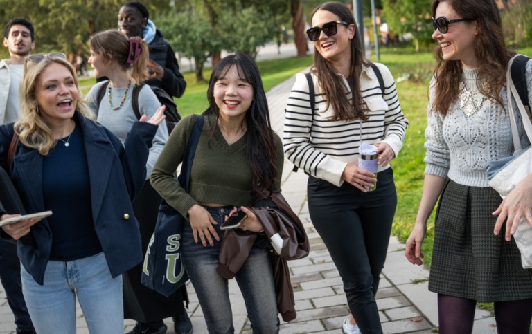 En grupp glada studenter på campus.